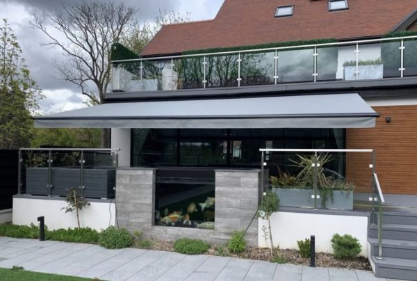 A sun awning outside a residential house overhanging a patio